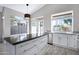 Bright kitchen featuring stainless steel appliances, white cabinetry, an island, and an adjacent breakfast nook with outdoor access at 115 W El Freda Rd, Tempe, AZ 85284
