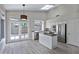 Bright kitchen featuring stainless steel appliances, white cabinetry, an island, and an adjacent breakfast nook with outdoor access at 115 W El Freda Rd, Tempe, AZ 85284