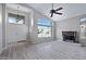 Spacious living room with fireplace, ceiling fan, high ceilings, large windows and wood flooring at 115 W El Freda Rd, Tempe, AZ 85284
