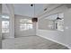 Living room showcasing gray wood flooring, modern pendant lighting, and plenty of natural light at 115 W El Freda Rd, Tempe, AZ 85284