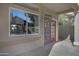 Covered patio with large window, red door with security screen, and neutral siding at 115 W El Freda Rd, Tempe, AZ 85284