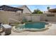 Backyard featuring a pool with unique water feature, desert landscaping, and privacy walls at 115 W El Freda Rd, Tempe, AZ 85284