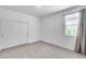 Bright bedroom featuring neutral carpet, window and a closet with sliding doors at 11574 W Luxton Ln, Avondale, AZ 85323