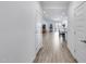 Inviting hallway with wood-look flooring leading to an open-concept living area with modern finishes and neutral tones at 11574 W Luxton Ln, Avondale, AZ 85323