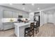 Well-lit kitchen features modern cabinets, stainless appliances, island with seating, and tile flooring at 11574 W Luxton Ln, Avondale, AZ 85323