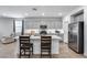 Bright kitchen featuring gray cabinets, stainless appliances, and a central island with seating for casual dining at 11574 W Luxton Ln, Avondale, AZ 85323