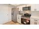 Updated kitchen with stainless steel appliances, white cabinets, and modern fixtures at 1301 N 44Th St, Phoenix, AZ 85008