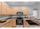 Well-lit kitchen with stainless appliances, black sink, and wood cabinets at 1351 N Pleasant Dr # 2051, Chandler, AZ 85225