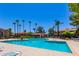 View of the pool and pool-side lounging area with lots of palm trees and condos at 1351 N Pleasant Dr # 2051, Chandler, AZ 85225