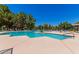 Community pool with several lounge chairs and mature landscaping around it at 1351 N Pleasant Dr # 2051, Chandler, AZ 85225