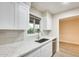 Bright kitchen with white cabinets, quartz counters, stainless steel sink, and neutral subway tile backsplash at 13611 N 98Th Ave # D, Sun City, AZ 85351
