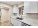 The kitchen features white cabinets, quartz countertops, tile backsplash and stainless appliances at 13611 N 98Th Ave # D, Sun City, AZ 85351