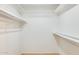 A walk-in closet includes upper shelves, lower shelves and hanging rods, creating ample storage space at 13611 N 98Th Ave # D, Sun City, AZ 85351