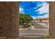 A wrought iron balcony overlooks a street, showcasing lush trees and the neighborhood under a bright, cloudy sky at 1367 S Country Club Dr # 1327, Mesa, AZ 85210