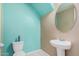 Bright half bathroom with turquoise accent wall, pedestal sink, and standard toilet at 1367 S Country Club Dr # 1327, Mesa, AZ 85210