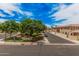 A view of the well-maintained community streets lined with green trees and beige residential buildings under a sunny sky at 1367 S Country Club Dr # 1327, Mesa, AZ 85210