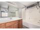 Well-lit bathroom with wood vanity, large mirror, and tub with shower at 14352 W Lamoille Dr, Surprise, AZ 85374