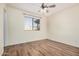 Bedroom with wood-look tile flooring and window overlooking the backyard at 14352 W Lamoille Dr, Surprise, AZ 85374