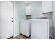 Convenient laundry room featuring modern washer and dryer, plus cabinetry at 14352 W Lamoille Dr, Surprise, AZ 85374