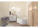 Bright bathroom features a soaking tub with marble surround and wood-look floors at 14390 W Morning Star Trl, Surprise, AZ 85374