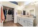 Bright bathroom features a walk-in closet, double sinks, and wood-look floors at 14390 W Morning Star Trl, Surprise, AZ 85374