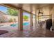 Covered patio with tiled floor offering views of the pool, spa and beautifully landscaped backyard at 14390 W Morning Star Trl, Surprise, AZ 85374