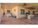 Spacious covered patio with tiled flooring, ceiling fans, and an outdoor dining area with a grill at 14390 W Morning Star Trl, Surprise, AZ 85374