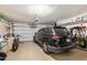 A two car garage featuring overhead storage, a parked car, and a bicycle at 14390 W Morning Star Trl, Surprise, AZ 85374
