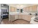 This kitchen features wooden floors, white cabinets, and views to the bedroom at 14390 W Morning Star Trl, Surprise, AZ 85374