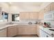 This kitchen features wooden floors, white cabinets, and natural light at 14390 W Morning Star Trl, Surprise, AZ 85374