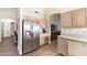 This kitchen features a stainless fridge and views to the living room at 14390 W Morning Star Trl, Surprise, AZ 85374