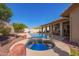 Backyard features a pristine pool and spa with ample patio space, ideal for outdoor gatherings and leisure at 14390 W Morning Star Trl, Surprise, AZ 85374