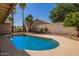 Backyard pool surrounded by lush landscaping, palm trees, and a privacy wall, perfect for outdoor enjoyment at 14390 W Morning Star Trl, Surprise, AZ 85374