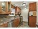 Updated kitchen features wood cabinetry, stainless steel appliances, and multicolored tile flooring at 1444 E Coronado Rd, Phoenix, AZ 85006