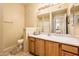Well-lit bathroom featuring wood cabinets and neutral finishes at 14950 W Mountain View Blvd # 7209, Surprise, AZ 85374