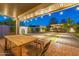 Backyard featuring a covered patio, outdoor seating area, and lush landscaping with professional outdoor lighting at 1513 E Sheridan St, Phoenix, AZ 85006