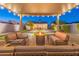 Backyard featuring covered outdoor living space with fire pit, lush landscaping with lighting, and a bocce ball court at 1513 E Sheridan St, Phoenix, AZ 85006