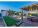 Beautiful backyard featuring a covered patio, fire pit, bocce ball court and professional landscaping with lighting at 1513 E Sheridan St, Phoenix, AZ 85006