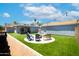 An outdoor backyard featuring an artificial lawn, a firepit encircled with chairs, trailer, and a shed at 1531 S Padre Rd, Apache Junction, AZ 85119