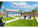 An outdoor backyard featuring an artificial lawn and a firepit encircled with chairs and overhead string lights at 1531 S Padre Rd, Apache Junction, AZ 85119