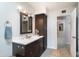 Bright bathroom featuring a vanity with a white countertop, a framed mirror, and a storage cabinet at 1531 S Padre Rd, Apache Junction, AZ 85119