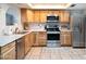 Well-lit kitchen featuring wooden cabinetry, stainless steel appliances, and tile flooring at 1531 S Padre Rd, Apache Junction, AZ 85119