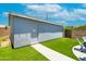 Rear view of an outbuilding with a backyard featuring an artificial lawn with a walkway and patio at 1531 S Padre Rd, Apache Junction, AZ 85119