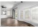 Bright living room featuring wood flooring, ceiling fans, and large windows at 1784 E Torrey Pines Ln, Chandler, AZ 85249
