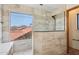 Bright bathroom features a glass shower, tile accents and a view of a desert neighborhood at 1813 E Sheena Dr, Phoenix, AZ 85022