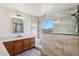 Bright bathroom features a shower with glass enclosure, tile accents, and a neighborhood view at 1813 E Sheena Dr, Phoenix, AZ 85022