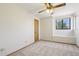 Cozy bedroom with natural light, neutral carpet, ceiling fan, and a framed window at 1813 E Sheena Dr, Phoenix, AZ 85022