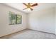 A bright bedroom with neutral carpet, standard window, and ceiling fan at 1813 E Sheena Dr, Phoenix, AZ 85022