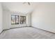 Bedroom with plush carpeting, two large windows, and vaulted ceiling at 1813 E Sheena Dr, Phoenix, AZ 85022