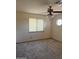 Carpeted bedroom featuring a ceiling fan, window, and unique round accent window at 1813 E Sheena Dr, Phoenix, AZ 85022